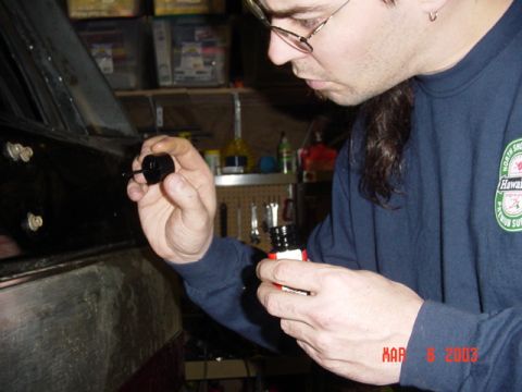 1989 Ford Bronco - A man works on a black vehicle door, applying touch-up paint.