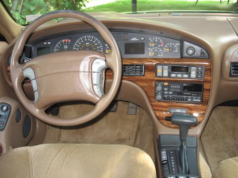 1992 Ford Crown Victoria - The dashboard of a car, a steering wheel, instrument cluster, and audio system.