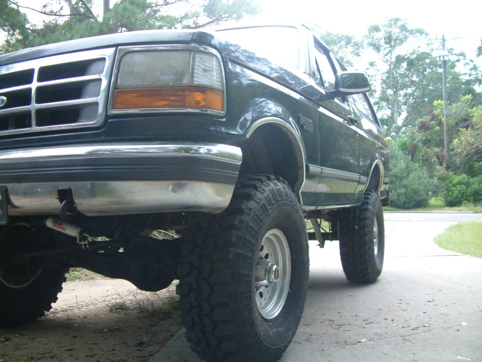 Dark green 1992 Ford Bronco front quarter view, lifted with large tires