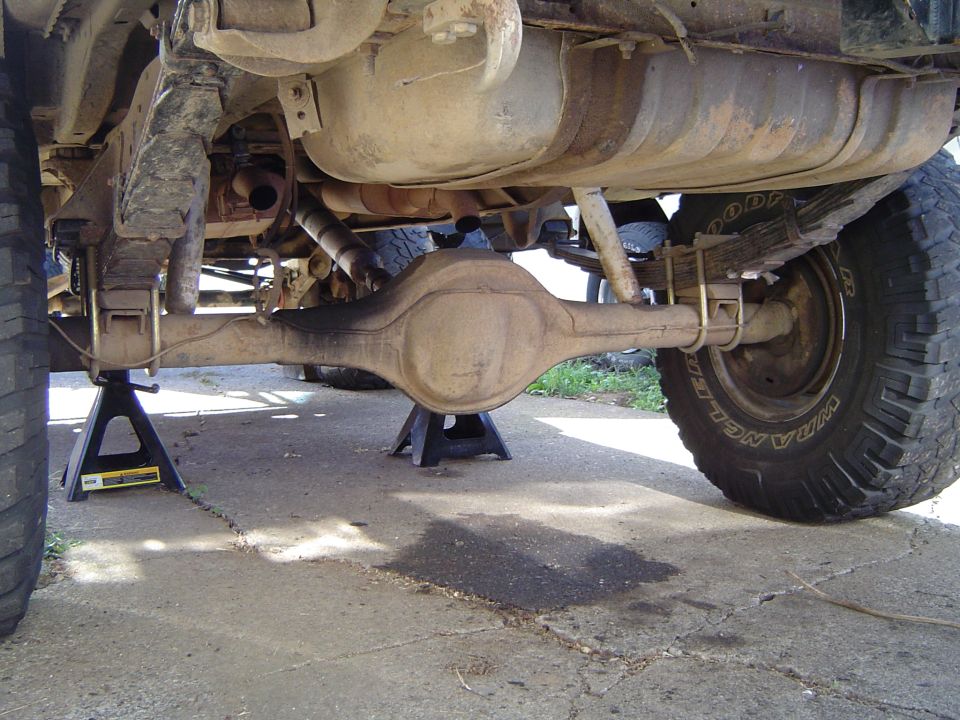 Underside view of a truck rear axle and leaf spring on jack stands