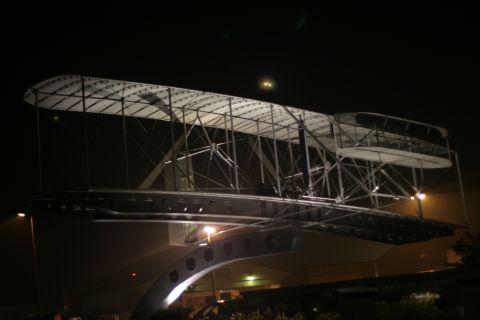 1997 Ford Probe - A replica of the Wright Flyer is illuminated at night.