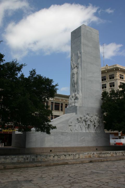 1997 Ford Probe - A large marble monument stands tall against a cloudy blue sky, with surrounding trees and buildings.