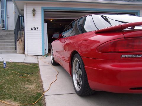 1994 Ford Probe - Red car parked in driveway with garage in background. The badge reads "PROBE".