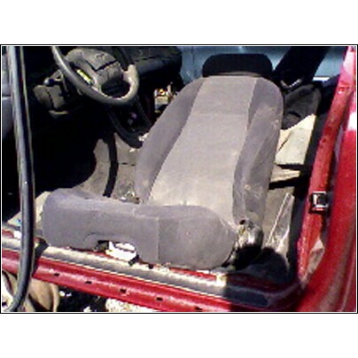 1973 Ford Ranchero - The interior of a vehicle shows a worn seat and dashboard area, with the red door frame in view.