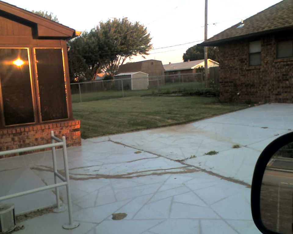 Backyard scene with a house, lawn, shed, and fence