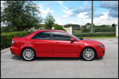 2006 Mazda 6 - Side profile of a red 2006 Mazda 6 sedan parked outdoors.