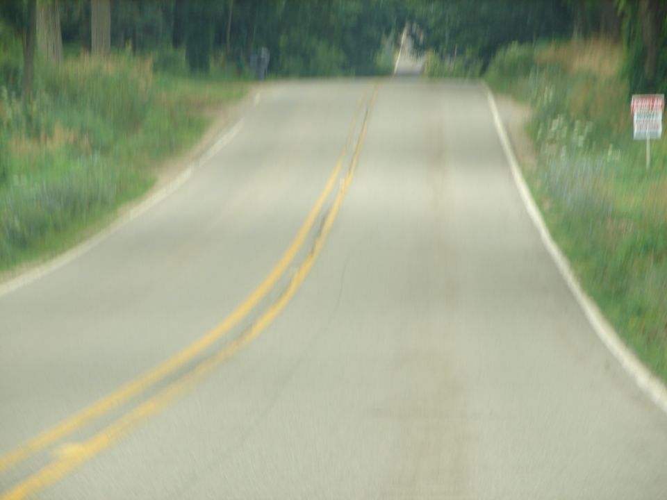 Road with double yellow lines and a sign on the right