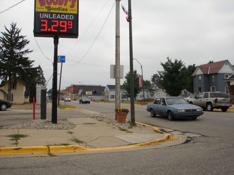 1992 Ford Taurus - A light blue sedan drives down a street with a gas station sign in the background.