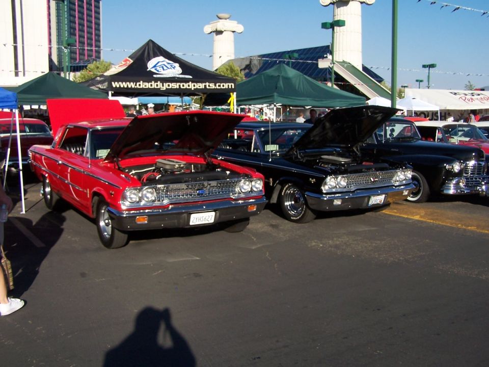 Red and black classic Ford cars with hoods open at a car show