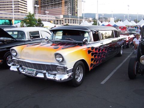 1990 Ford Bronco - A customized limousine with a flame paint job is parked at an outdoor event.