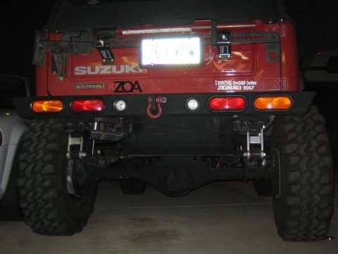 1987 Suzuki Samurai - Rear view of a red 1987 Suzuki Samurai, showing its bumper, taillights, and spare tire mount.