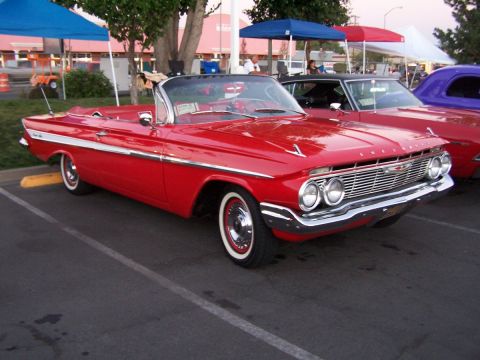 1990 Ford Bronco - Classic red 1961 Chevrolet Impala convertible at an outdoor event.