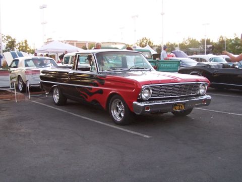 1990 Ford Bronco - A classic Ford Falcon Ranchero with custom flame paint is displayed at a car show.