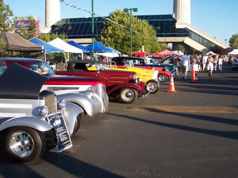 1990 Ford Bronco - A row of classic cars are displayed at an outdoor event under a clear blue sky.
