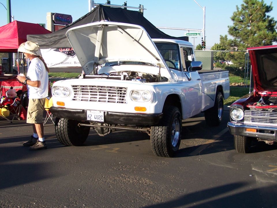 White pickup truck front view, hood open. License plate 62 4U2C