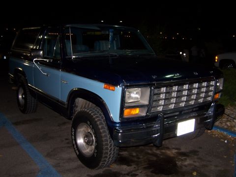 1990 Ford Bronco - This two-tone blue Ford Bronco is parked at night.