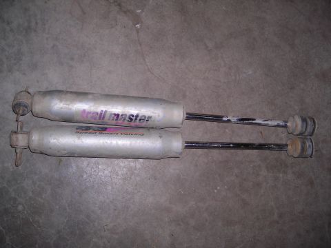 2003 Jeep TJ - Pair of Trail Master shock absorbers, likely for an off-road vehicle, shown on a concrete surface.