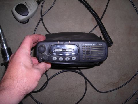 2003 Jeep TJ - A Motorola CDM750 radio unit is shown with its microphone and antenna, held by a person's hand.