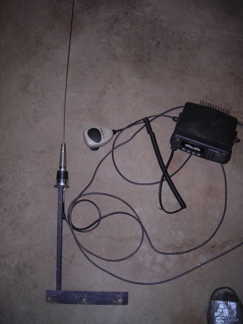 2003 Jeep TJ - CB radio and antenna set with microphone, laid out on a concrete surface.