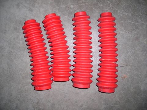 2003 Jeep TJ - Four red accordion-style dust boots are shown on a gray concrete surface.