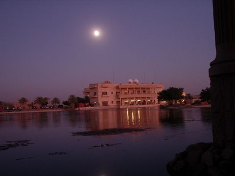 1996 Ford Bronco - A building stands by the water under a full moon, with its lights reflecting on the surface.