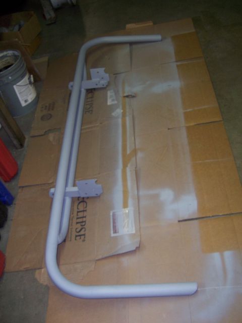 1991 Ford Bronco - A light gray tubular rear bumper assembly is shown laid out on cardboard, likely in preparation for painting.