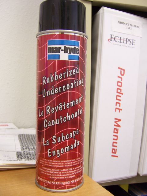 1991 Ford Bronco - A can of rubberized undercoating sits on a shelf next to product manuals.