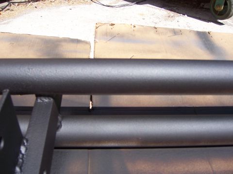 1991 Ford Bronco - Close-up view of a custom-made black steel bumper, showing its construction and attachment points.