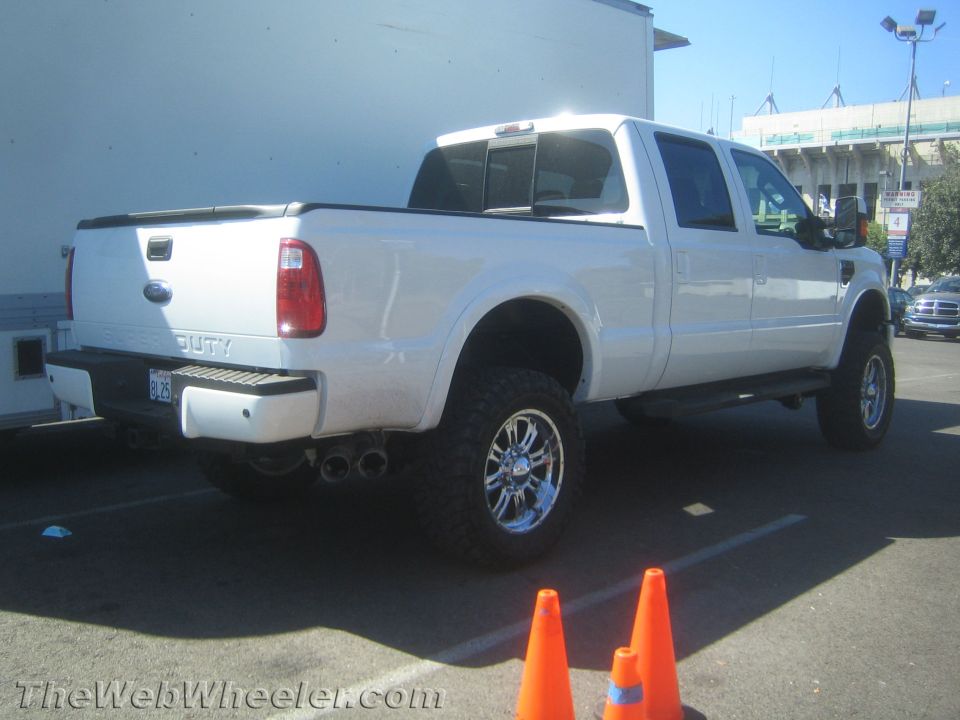 White Ford F-250 Super Duty pickup truck with chrome wheels and dual exhaust