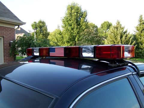 2003 Ford Crown Victoria - Emergency light bar mounted on the roof of a dark blue 2003 Ford Crown Victoria.