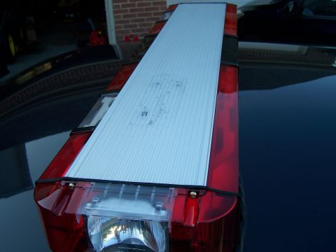 2003 Ford Crown Victoria - The light bar has red lenses and a silver panel with horizontal lines.