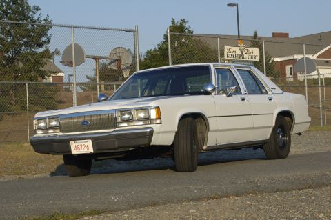 1991 Ford Crown Victoria LTD - White 1991 Ford Crown Victoria LTD seen from the front-left angle near a basketball court.