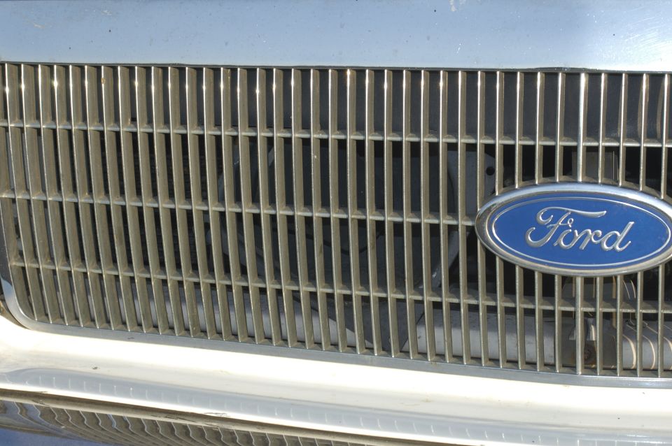 Close-up of a Ford oval badge on a chrome grille