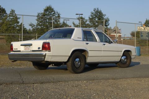 1991 Ford Crown Victoria LTD - White 1991 Ford Crown Victoria LTD sedan seen from the rear quarter angle.