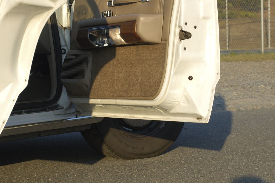 Open car door showing interior panel, speaker, and tire