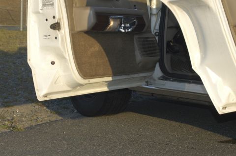 1991 Ford Crown Victoria LTD - The interior door panel of a white vehicle is visible with the door ajar.
