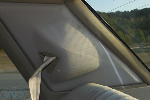 1991 Ford Crown Victoria LTD - Interior shot of a car's rear pillar and seat, with sunlight streaming through the back window.