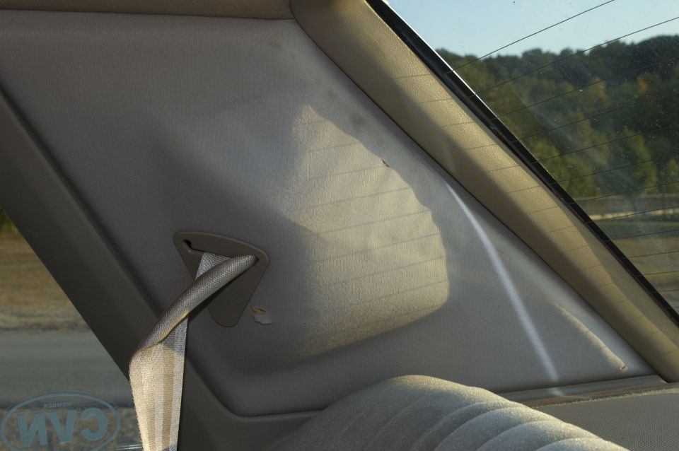Rear pillar and seat fabric inside a car. Sun is shining through the rear window