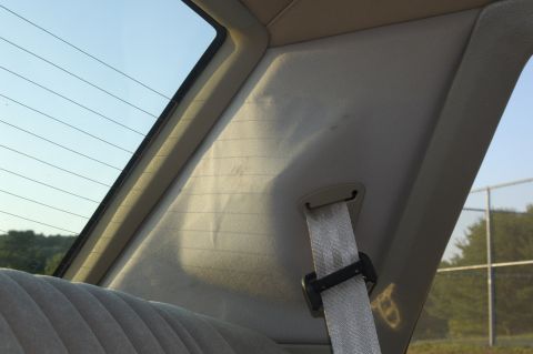 1991 Ford Crown Victoria LTD - Interior view of a car's rear pillar and seat, with a seatbelt and rear window visible.