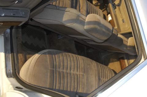 1991 Ford Crown Victoria LTD - The interior of a car features plush cloth seats and textured floor mats, viewed from the passenger side.