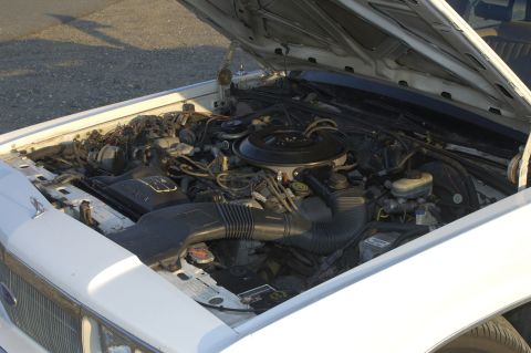 1991 Ford Crown Victoria LTD - The engine bay of a 1991 Ford Crown Victoria LTD is shown with the hood open.