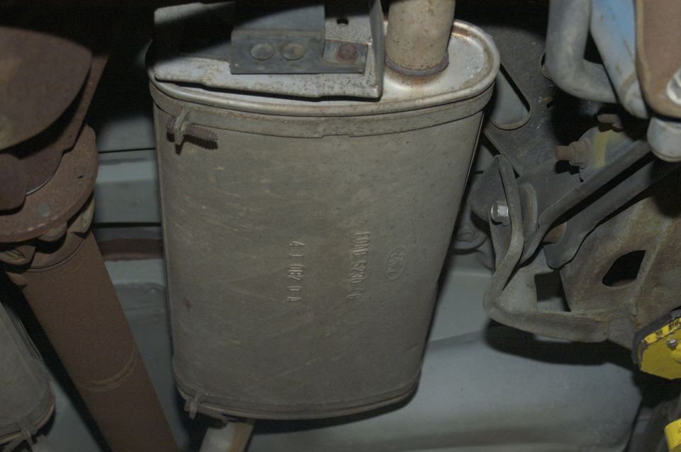 Exhaust muffler with Ford logo and part numbers stamped on its side