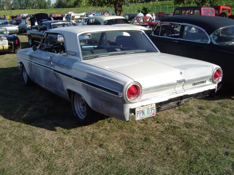 1964 Ford Fairlane - A white 1963 Ford Falcon is parked on a grassy field at an outdoor car show.