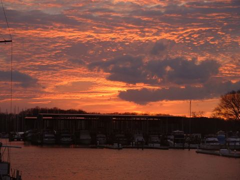 1994 Ford Bronco - A marina scene at sunset with boats docked and a colorful sky.