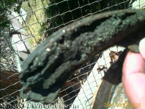 1987 Suzuki Samurai - A heavily worn brake shoe is shown, covered in dirt and debris.
