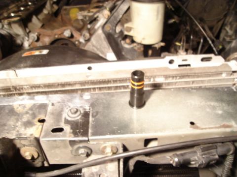 2000 Ford Crown Victoria - Close-up view of a vehicle's engine bay, focusing on the radiator and a small component.