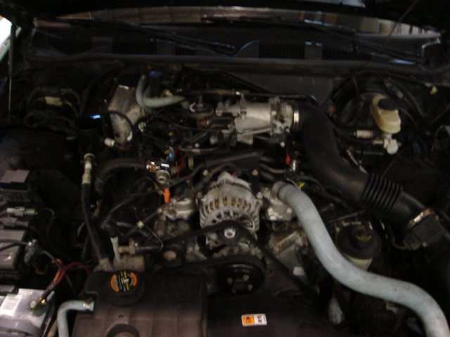 Engine bay of a 2000 Ford Crown Victoria, showing the V8 engine, alternator, and intake system