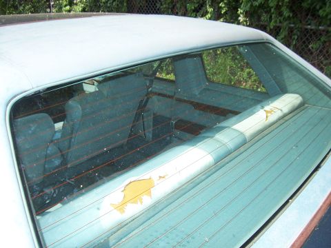 1999 Ford Crown Victoria - The parcel shelf has a graphic that is peeling off, revealing yellow underneath.