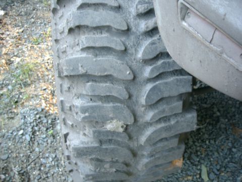 1991 Chevrolet Suburban - A close-up view of a large off-road tire with a tread pattern, partially obscuring the vehicle's fender.