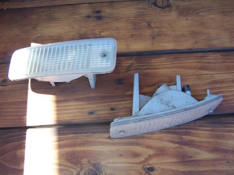 1994 Ford Probe - Two automotive light assemblies are displayed on a wooden background.